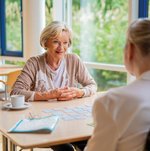 Eine Ehrenamtliche spielt mit einer Bewohnerin ein Brettspiel