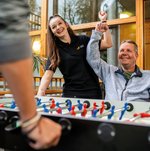 Eine Ehrenamtliche spielt mit einem Bewohner Tischkicker.