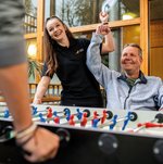 Eine Ehrenamtliche spielt mit einem Bewohner Tischkicker.