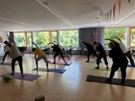 Eine Gruppe Mitarbeitende beim Yoga