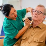 Eine Pflegerin rasiert einen Mann