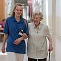 Mitarbeiter der Altenhilfe hilft Seniorin